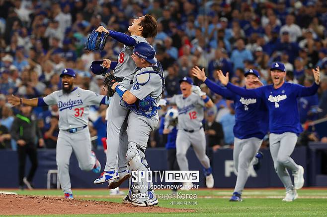 ▲ 포스트시즌에서 공수 모두 좋은 활약을 하며 다저스를 이끈 윌 스미스가 우승 확정 후 야마모토 요시노부를 끌어안고 있다