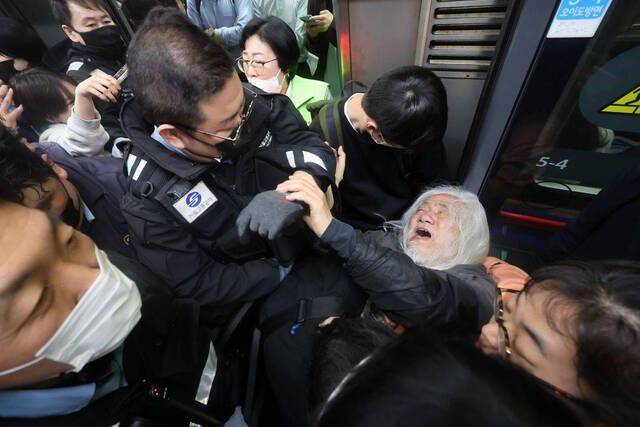 박경석 전국장애인차별철폐연대(전장연) 대표가 지난 4월 지하철 4호선 혜화역에서 제62차 ‘출근길 지하철 탑니다’ 시위를 벌이던 중 이를 저지하던 서울교통공사 관계자와 충돌하고 있다. 연합뉴스