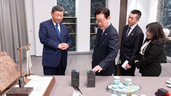 이재명 대통령이 1일 시진핑 중국 국가주석이 선물한 샤오미 스마트폰을 살펴보고 있다. 사진 대통령실