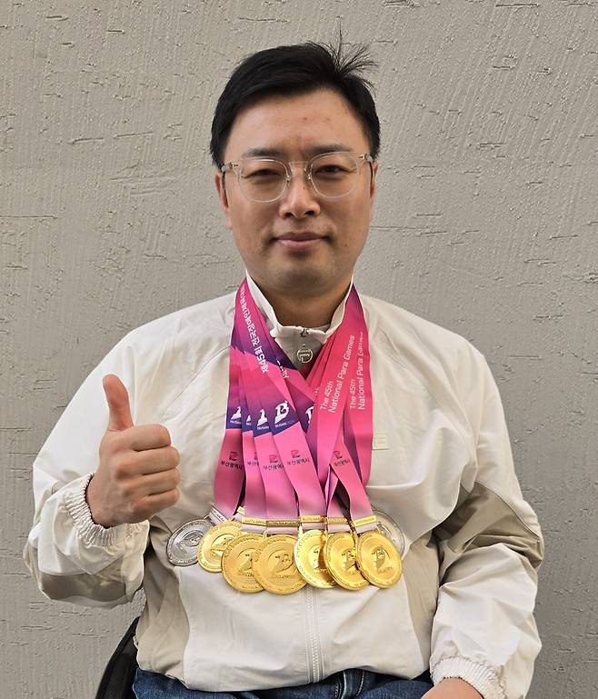 김정남이 금메달 6개, 은메달 2개 등 제45회 전국장애인체육대회에서 딴 메달을 목에 걸고 포즈를 취하고 있다. 대한장애인체육회