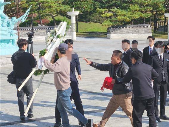 장동혁 국민의힘 당 대표가 6일 오후 3시50분쯤 광주를 찾아 국립 5·18민주묘지를 참배하기 위해 추모의 문 앞에 도착하기 직전 광주전남촛불행동 회원들이 당 대표 조화를 치우고 있다. 이 과정에서 국민의힘 관계자와 촛불행동 회원 간 '뺏고 빼앗기는' 격렬한 몸싸움이 벌어졌다. ⓒ 시사저널 정성환