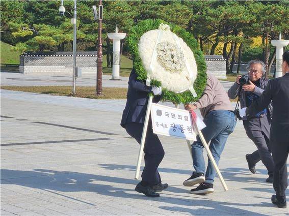 장동혁 국민의힘 당 대표가 6일 오후 3시50분쯤 광주를 찾아 국립 5·18민주묘지를 참배하기 위해 추모의 문 앞에 도착하기 직전 광주전남촛불행동 회원들이 당 대표 조화를 치우고 있다. 이 과정에서 국민의힘 관계자와 촛불행동 회원 간 '뺏고 빼앗기는' 격렬한 몸싸움이 벌어졌다. ⓒ 시사저널 정성환