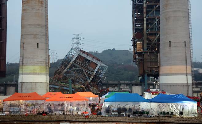 7일 새벽 울산 남구 동서발전 울산화력발전소 보일러 타워 붕괴현장에서 소방대원들이 매몰자 수색 및 구조작업을 벌이고 있다. 뉴스1