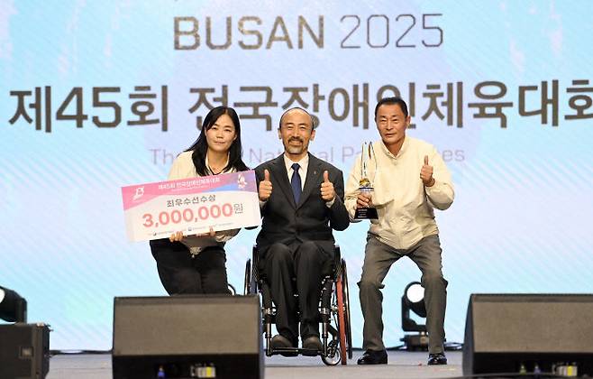 임규모 세종시장애인체육회 무처장, 이연경 총괄부장, 정진완 대한장애인체육회장으로부터 사격 부문 김정남의 최우수선수상을 대리 수상하고 있다. 사진=세종시 제공.
