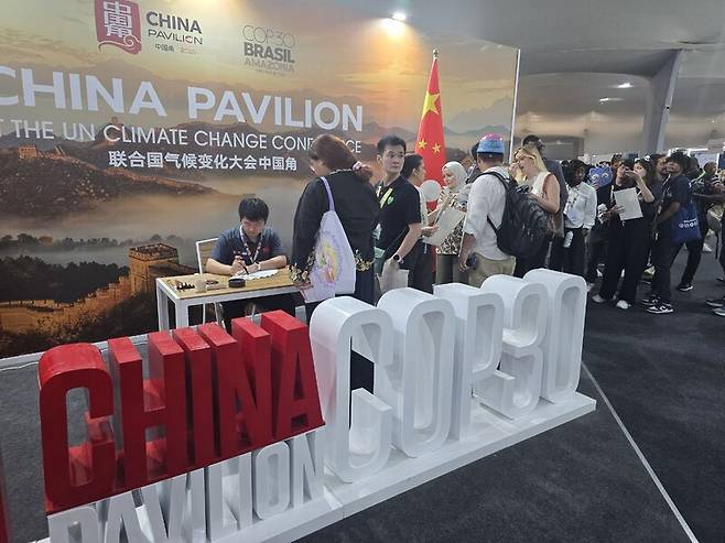 제30차 유엔 기후변화협약 당사국총회(COP30)가 개막한 10일(현지시각) 브라질 벨렝 도시공원에 마련된 ‘블루존’의 중국 홍보 부스에 기념품을 받기 위한 줄이 길게 늘어서 있다. 옥기원 기자