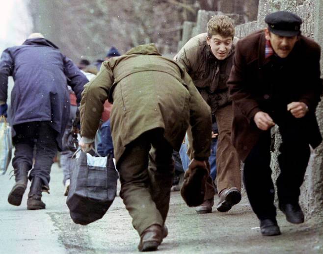 보스니아 내전이 벌어진 지난 1993년 사라예보에서 시민들이 저격을 피하기 위해서 몸을 숙여서 걸어가고 있다. 로이터 연합뉴스