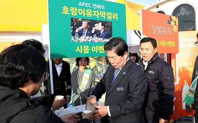 공영민 고흥군수가 유자축제장을 찾은 관광객들에게 APEC 정상회의 공식 만찬주로 활용된 호랑이 생유자 막걸리를 권하고 있다. ⓒ고훙군 