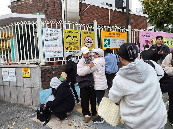 광남고 시험장 교문 앞에서 수험생 딸을 꼭 안아주고 있는 어머니의 모습.ⓒ데일리안 허찬영 기자