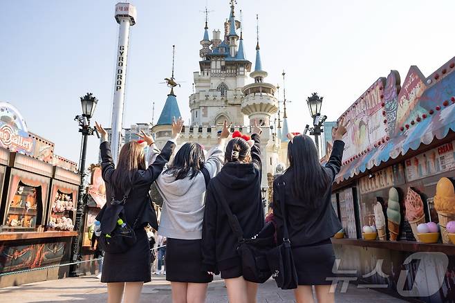 롯데월드 어드벤처 매직아일랜드 앞에서 인증 사진을 찍고 있는 수험생들(롯데월드 제공)