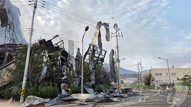 이랜드 물류창고 화재 이틀 째인 16일 충남 천안 동남구 이랜드패션 물류센터 주변 전깃줄에 창고에서 떨어져 나온 샌드위치 패널이 걸려 바람에 흔들리고 있다. 소방당국은 대응1단계를 유지한 채 화재 진압을 이어가고 있다. 2025.11.16/ 2025.11.16/뉴스1 ⓒ News1 이시우 기자