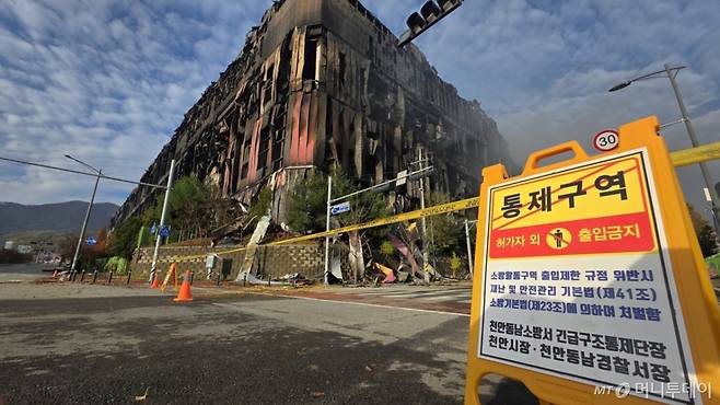 (천안=뉴스1) 이시우 기자 = 충남 천안 동남구 이랜드패션 물류센터 화재 이틀 째인 16일, 화재 현장 주변에 출입 금지 표지판이 설치돼 있다. 소방당국은 대응1단계를 유지한 채 화재 진압을 이어가고 있다. 2025.11.16/뉴스1 Copyright (C) 뉴스1. All rights reserved. 무단 전재 및 재배포, AI학습 이용 금지. /사진=(천안=뉴스1) 이시우 기자