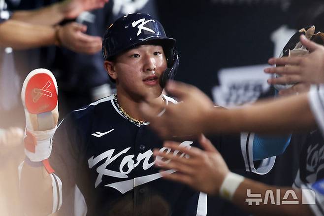 한국 3회초 공격 1사 주자 2, 3루서 문보경의 내야 땅볼 때 3루 주자 안현민이 홈인한 뒤 더그아웃에서 동료들과 하이파이브하고 있다.