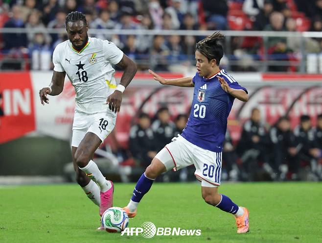 일본 축구대표팀 구보 다케후사(오른쪽)가 14일 일본 도요타 스타디움에서 열린 가나와의 축구 국가대표팀 A매치 친선경기에서 볼 경합을 펼치고 있다. /AFPBBNews=뉴스1
