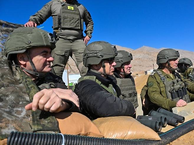 19일(현지시각) 베냐민 네타냐후 이스라엘 총리(가운데 검은옷)가 이스라엘 카츠(왼쪽) 이스라엘 국방장관, 에얄 자미르 참모총장(오른쪽)과 함께 시리아 완충지대에 있는 이스라엘군 기지를 방문했다. 이스라엘 총리실 제공