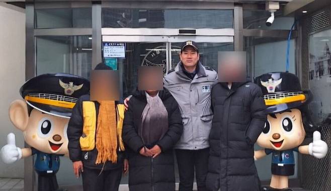 박아론 경위가 서울역파출소 앞에서 노숙인들과 사진을 찍고 있다. /박아론 경위 제공