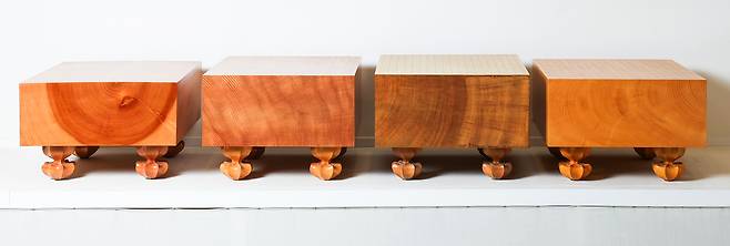 완성된 다양한 품질의 바둑판. 나이테의 중심부가 포함된 하급 바둑판부터 색이나 결이 고른 상급 바둑판이 왼쪽부터 순서대로 놓여있다. 맨 오른쪽은 본비자 바둑판.