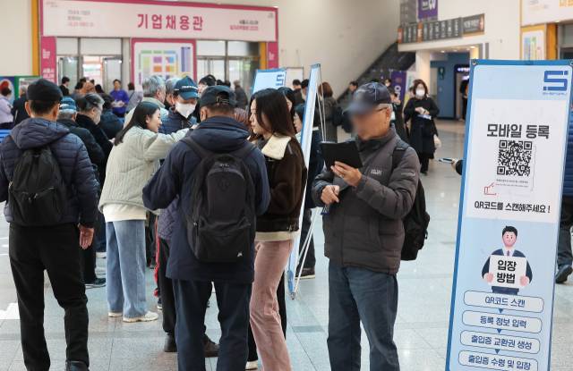 서울 강남구 대치동 세텍에서 열린 '서울시 시니어 일자리박람회 2025'를 찾은 구직자들이 입장을 하기 위해 모바일 등록을 하고 있다. 연합뉴스.