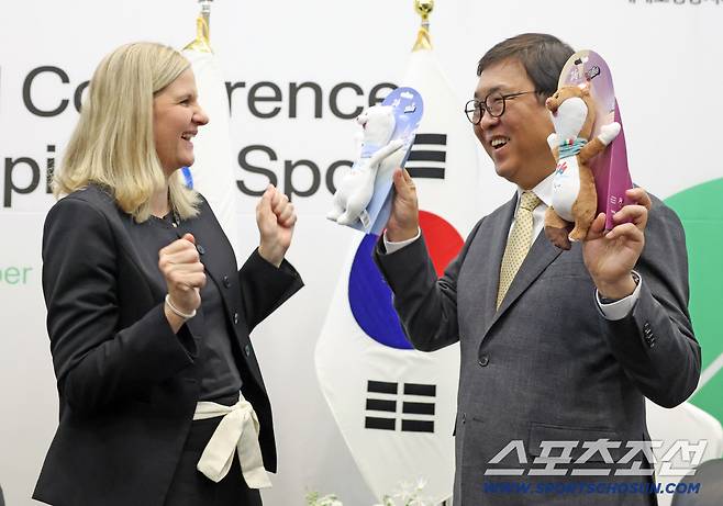 최휘영 장관이 커스티 코번트리 국제올림픽위원회 위원장으로부터 밀라노코르티나올림픽 마스코트 인형을 선물받은 후 환한 미소를 짓고 있다. 사진제공=문화체육관광부