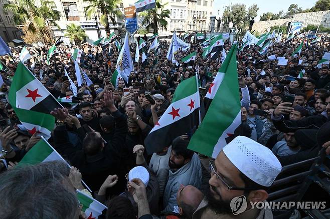 '아사드 축출 기념' (다마스쿠스 AFP=연합뉴스) 지난달 28일(현지시간) 시리아 시민들이 알아사드 독재정권 축출 1주년을 기념하며 행진 중이다. 2025.12.5 photo@yna.co.kr