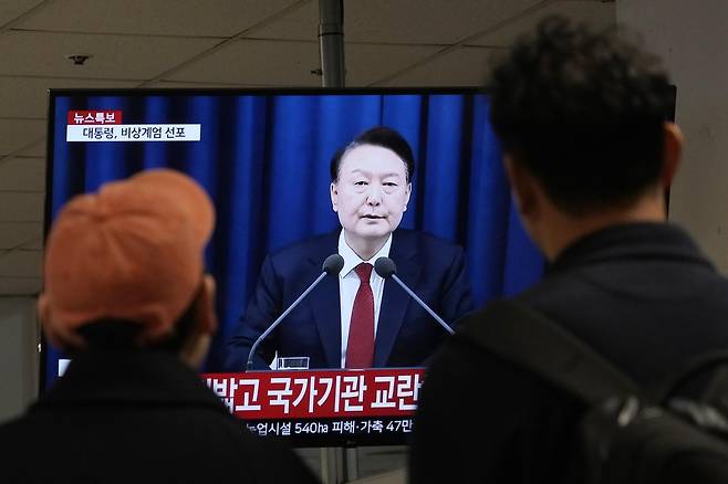 지난해 12월 3일 윤석열 전 대통령의 계엄 선포 생중계 뉴스를 시민들이 지켜보고 있다. AP 뉴시스