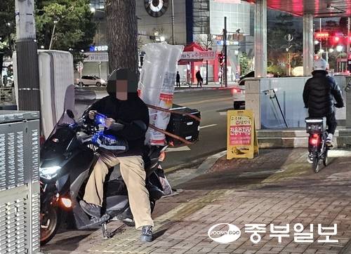 지난 6일 오후 하남시청 앞 인도에서 쉼터를 찾지 못한 배달 라이더가 오토바이에서 대기 중이다. 한바오로기자