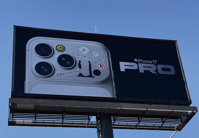 대형 옥외광고판에 걸린 아이폰17 프로 이미지 위로 지드래곤의 앨범·브랜드명이 붙은 모습. 사진=인스타그램 계정 'newsourcemag' 캡처
