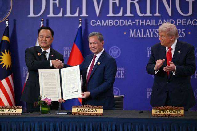 10월 26일 말레이시아 쿠알라룸푸르에서 열린 태국-캄보디아 휴전 협정 서명식에서 도널드 트럼프(오른쪽) 미국 대통령이 아누틴 찬위라꾼(왼쪽) 태국 총리와 훈 마네트(가운데) 캄보디아 총리를 바라보며 박수를 치고 있다. 쿠알라룸푸르=AFP 연합뉴스