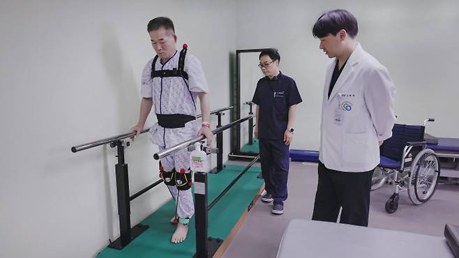 ETRI가 개발한 초경량 탄성슈트를 입고 충북대병원 의료진과 재활훈련하는 환자. ETRI 제공