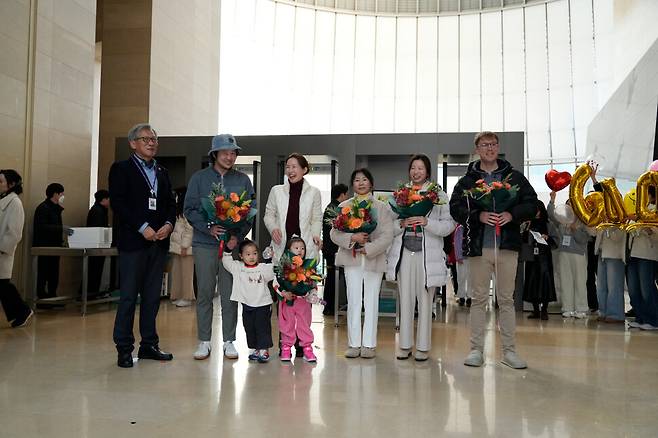 국립중앙박물관 상설관의 보안검색대를 넘은 직후 600만명째 국내 관람객으로 인증된 시민 노용욱(40)씨 가족과 600만명 돌파 뒤 첫 외국인 관람객으로 기록된 덴마크인 관객 레서가 유홍준 관장과 축하 사진을 찍고 있다. 국립중앙박물관 제공