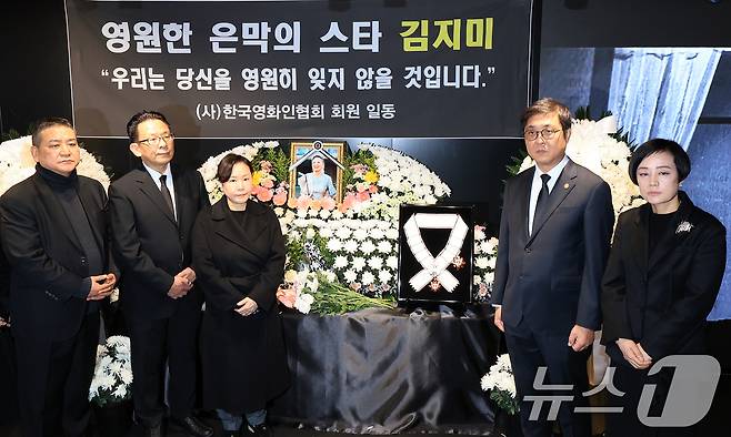 최휘영 문화체육관광부 장관(오른쪽 두 번째)이 14일 서울 중구 서울영화센터에 마련된 고 김지미 배우의 추모공간을 찾아 금관문화훈장을 전달한 뒤 유가족 및 영화업계 관계자들과 기념촬영을 하고 있다. 2025.12.14/뉴스1 ⓒ News1 이호윤 기자