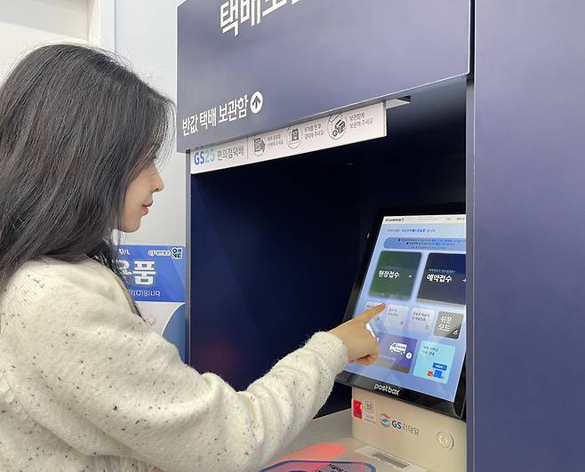 GS25는 이달 29일 다음날 도착하는 내일반값, 내일택배 서비스 2종을 선보인다. 사진은 한 고객이 GS25에서 택배를 접수하고 있는 모습. <자료 = GS25>