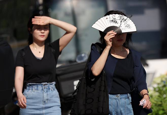 폭염이 계속되는 10일 서울 종로구 거리에서 한 시민이 부채로 햇볕을 피하며 이동하고 있다. 2025.07.10. 뉴시스