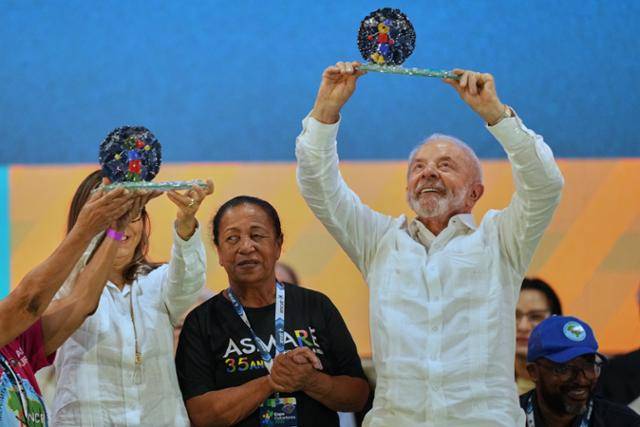 루이스 이나시우 룰라 다시우바 브라질 대통령이 19일 상파울루에서 열린 재활용 쓰레기 수거 노동자 가족들과 함께한 크리스마스 행사에서 받은 선물을 들어올리고 있다. 상파울루=AP 뉴시스