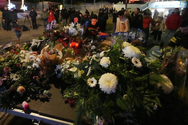 사고 현장인 스위스 크랑몽타나 르 콩스텔라시옹 바 주변에 1일 시민들이 헌화하는 모습. AP 연합뉴스
