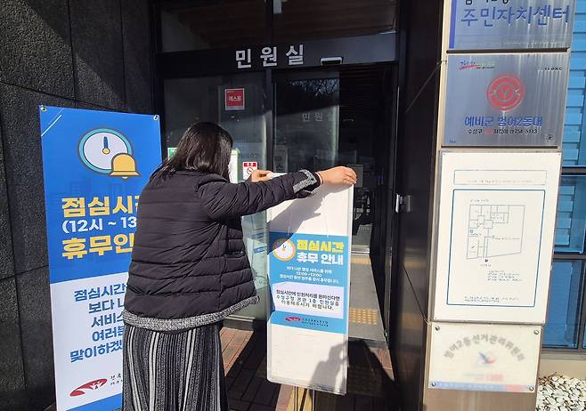 '오늘부터 점심시간 쉽니다' (대구=연합뉴스) 박세진 기자 = 2일 대구 수성구 범어2동 행정복지센터 직원이 출입문에 점심시간 휴무를 알리는 안내판을 설치하고 있다. 2026.1.2. psjpsj@yna.co.kr