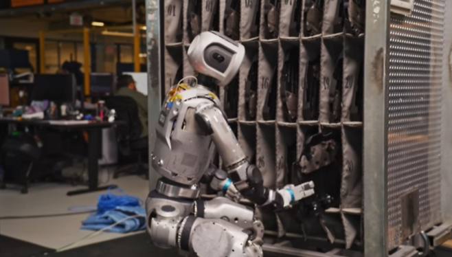 보스턴다이내믹스의 ‘올 뉴 아틀라스’가 엔진 커버를 골라 지정 자리로 옮기는 훈련을 하고 있는 모습.