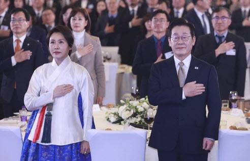 이재명 대통령과 김혜경 여사가 4일 중국 베이징 한 호텔에서 열린 재중 한국인 간담회에서 국기에 경례하고 있다. (사진=연합뉴스)