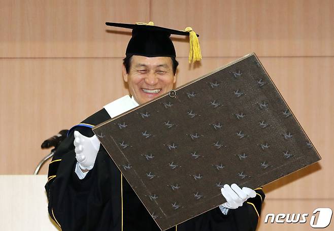 영화배우 안성기가 지난 2019년 경기도 수원시 경기대학교 수원캠퍼스에서 열린 명예문화박사 학위수여식에 참석해 기념패를 보며 미소짓고 있다. 2019.11.7/뉴스1 ⓒ News1