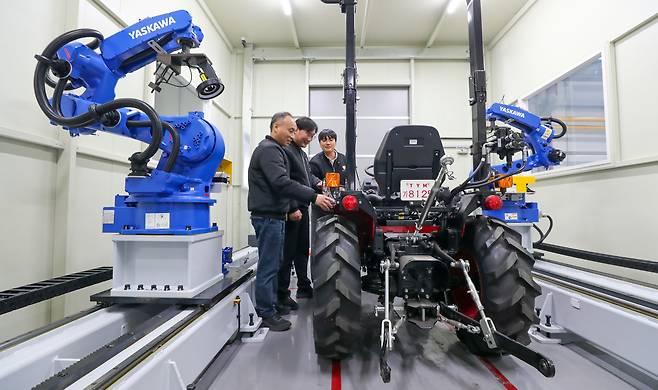지난달 23일 전북 익산시 왕궁면 TYM 익산 공장에서 직원들이 트랙터 주변에서 AI 기반 자율 검사 기기의 가동 과정을 점검하고 있다. 농기계 업체 TYM은 별도의 인력을 투입하지 않아도 하루에 트랙터 26대를 검사할 수 있는 AI 장비를 올해부터 현장에 투입할 예정이다. /김영근 기자