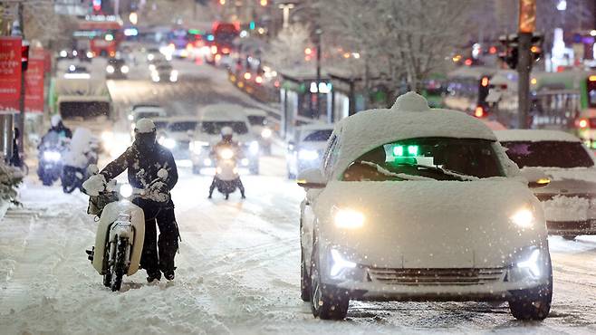 서울·인천·경기·강원 등 4개 시도에 대설특보가 발효된 지난해 12월4일 서울 마포구 홍대 인근에서 제설작업이 완료되지 못한 곳을 지나는 차량이 힘겹게 언덕길을 오르고 있다. 연합뉴스