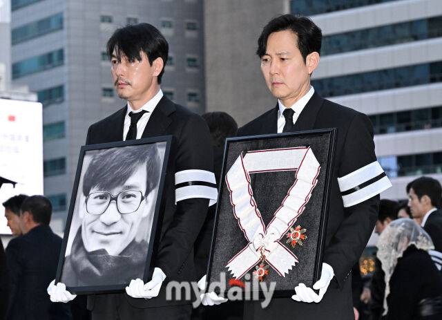 배우 정우성과 이정재가 9일 오전 서울 명동성당에서 진행된 故안성기 추모 미사 및 영결식에서 고인의 영정과 훈장을 들고 있다./마이데일리