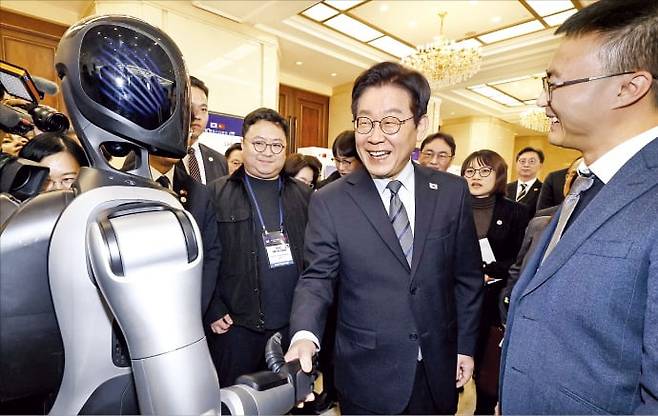 이재명 대통령이 7일 중국 상하이 국제회의중심에서 열린 한·중 벤처스타트업 서밋에서 중국 로봇 스타트업인 애지봇이 만든 휴머노이드와 악수하고 있다. /연합뉴스