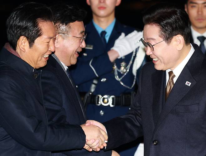 14일 오후 일본 순방 일정을 마치고 서울공항으로 귀국한 이재명 대통령이 마중나온 정청래 더불어민주당 대표와 인사하고 있다./뉴시스