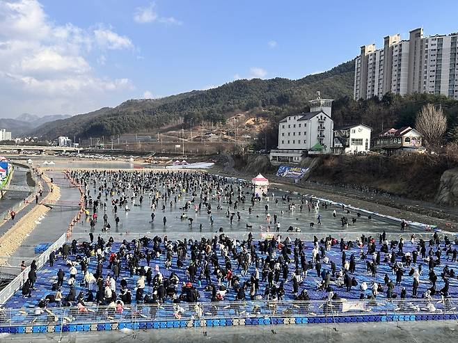 주말인 지난 10일 강원 홍천군 ‘홍천강 꽁꽁축제’ 의 얼음낚시와 폰툰(부교) 낚시터에 많은 인파가 몰려 송어낚시 체험을 하고 있다. 홍천군 제공