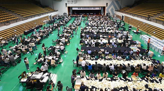 제8회 전국동시지방선거 투표일인 2022년 6월 1일 오후 경기 수원시 영통구 아주대학교 체육관에 마련된 개표소에서 개표사무원들이 개표를 하고 있다./뉴스1