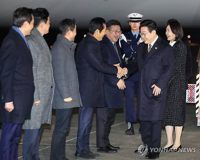 이재명 대통령, 일본 일정 마치고 귀국 (성남=연합뉴스) 김도훈 기자 = 일본 방문 일정을 마치고 귀국한 이재명 대통령이 14일 성남 서울공항에서 더불어민주당 정청래 대표와 인사하고 있다. 이 대통령 왼쪽부터 윤호중 행정안전부 장관, 정 대표, 한병도 원내대표, 강훈식 대통령비서실장, 우상호 정무수석. 2026.1.14 superdoo82@yna.co.kr