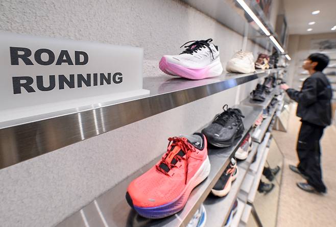 최근 20·30대를 중심으로 '러닝코어' 문화가 빠르게 확산되고 있는 가운데 21일 오후 수원시 팔달구 AK플라자 내 운동복 판매점에서 관계자가 러닝화 매대를 정리하고 있다. 임채운기자