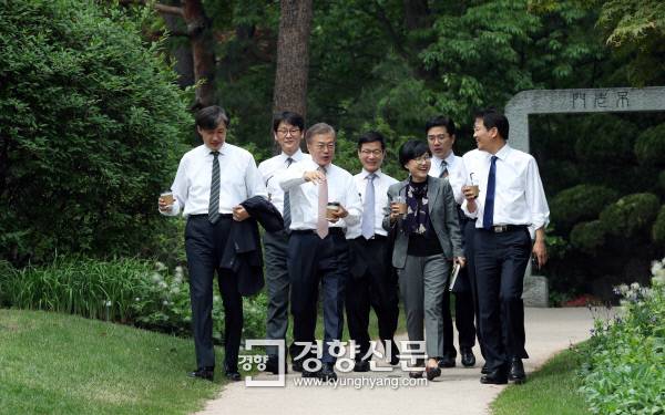 문재인 대통령 취임 사흘째인 2017년 5월 11일 ,문 대통령이 신임 수석 비서관들과 오찬을 갖은 후 청와대 소공원에서 차담회를 갖기 위해 이동하고 있다. 왼쪽부터 조국 민정수석, 권혁기 춘추관장, 문 대통령, 이정도 총무비서관, 조현옥 인사수석, 송인배 전 더불어민주당 선대위 일정총괄팀장, 윤영찬 홍보수석, 임종석 비서실장. / 청와대사진기자단