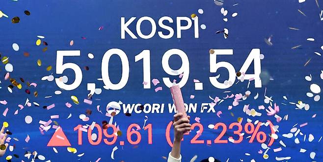 코스피 지수가 장중 사상 처음으로 5019.54를 기록한 22일 서울 중구 우리은행 본점 딜링룸에서 딜러들이 코스피 지수 5000선 돌파를 축하하고 있다. 연합뉴스