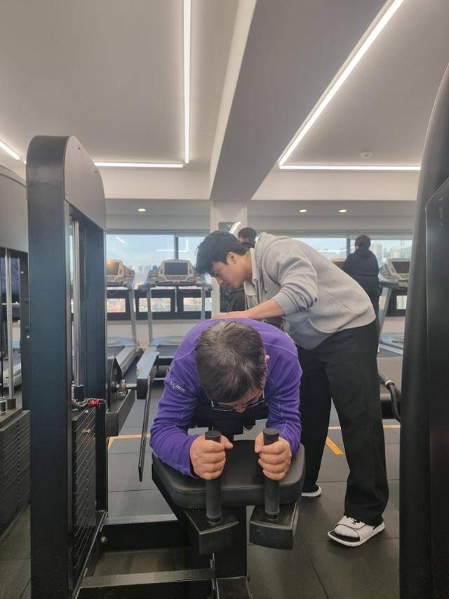 20일 서울 동작구 상도동의 장애인 전용 헬스장에서 장홍수씨가 홍성윤 체육지도사의 지도를 받으며 하체 근력 운동을 하고 있다. 김지섭 기자